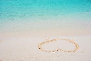 Fototapeta na wymiar heart on the sand. Coast on a tropical island, honeymoon by the sea.