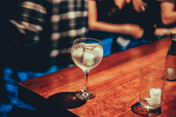 Cup of gin-tonic on wooden bar table