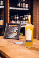 Bottle of yellow limoncello with label and white cap in wine shop in Barcelona