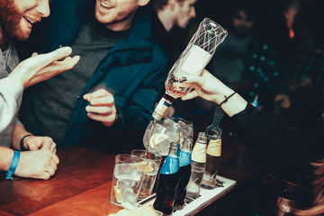 Waitress at bar counter serving alcohol to customers