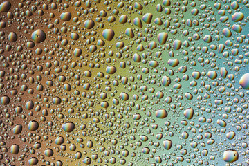 Drops of water on the glass, with the reflection of the rainbow.