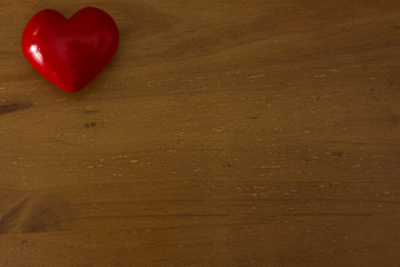 shiny red heart on a timber background