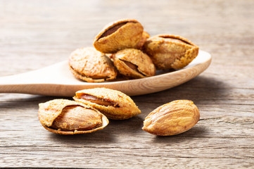 Roasted almonds and peel on old wooden table