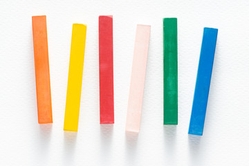 various of colorful chalks crayon or pastel stick on white rough paper