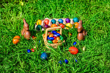 Chocolate Easter bunnies with eggs in grass