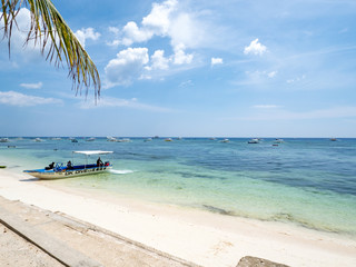 Beautiful tropical beach background from Alona Beach at Panglao Bohol island with beach chairs on the white sand beach with cloudy blue sky and palm trees. Travel Vacation, november 2018