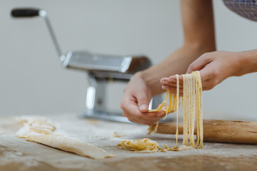 Housewife holds noodles in hands and on a white background. On t