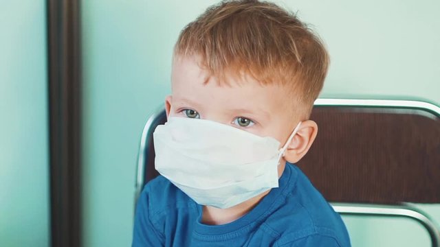 Little boy, a child in a medical mask in the hospital. The concept of an epidemic, influenza, protection from disease, vaccination.