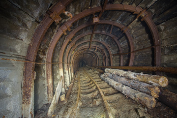 Underground abandoned gold iron ore mine shaft tunnel gallery passage wtih metal timbering