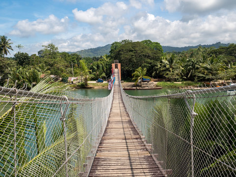 Pedestrian hanging bridge over river in tropical forest, Bohol, Philippines. November, 2018