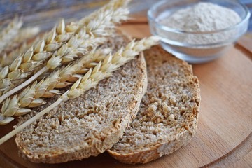Healthy bread made of whole wheat flour and ears on a wooden Board.