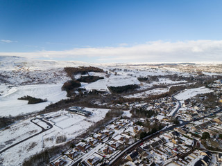 Aerial view of a small Welsh village called Nantyglo in South Wales with community and council housing  covered in snow at winter