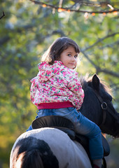 girl riding a pony in the autumn Park.