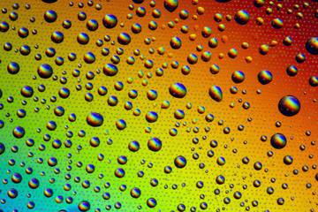 Drops of water on the glass, with the reflection of the rainbow.