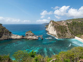Indonesia, november 2018: Beautiful scenic panoramic landscape view of exotic Atuh beach of Nusa Penida Island in Bali. Palm trees,turquoise clear water and warm white sand beach. Popular destination.