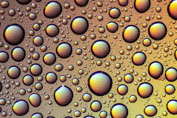 Drops of water on the glass, with the reflection of the rainbow.