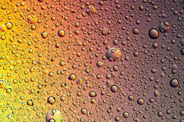 Drops of water on the glass, with the reflection of the rainbow.