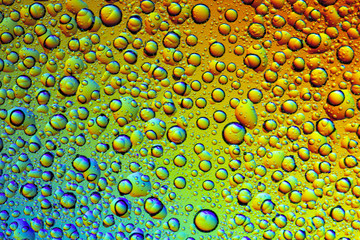 Drops of water on the glass, with the reflection of the rainbow.