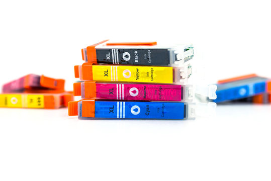 Close-up shot of a CMYK ink cartridges for a color printer isolated on a white background.
