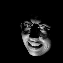 Stylish portrait of attractive caucasian woman in glasses. Black and white shot, low-key lighting. Isolated on black.
