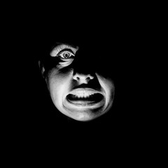 Portrait of a scared caucasian woman. Scary and fear concept. Black and white shot, low key lighting. Isolated on black.