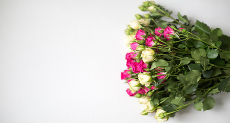 Pink and white rose bush collected in a bouquet. Beautiful floristry for weddings, holidays. Floral decoration of flowers. Copy space and top view. Panorama light background.