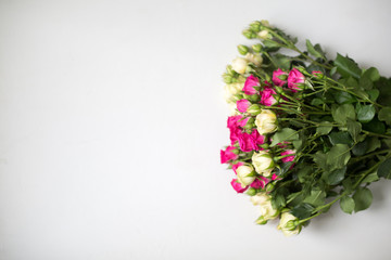 Pink and white rose bush collected in a bouquet on a light background. Beautiful floristry for weddings, holidays. Floral decoration of flowers. Copy space and top view.