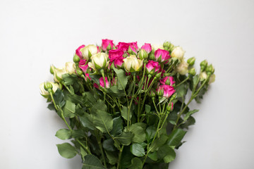 Pink and white rose bush collected in a bouquet. Beautiful floristry for weddings, holidays. Floral decoration of flowers. Top view light background.