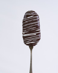 Chocolate cake pop on vintage spoon on light background