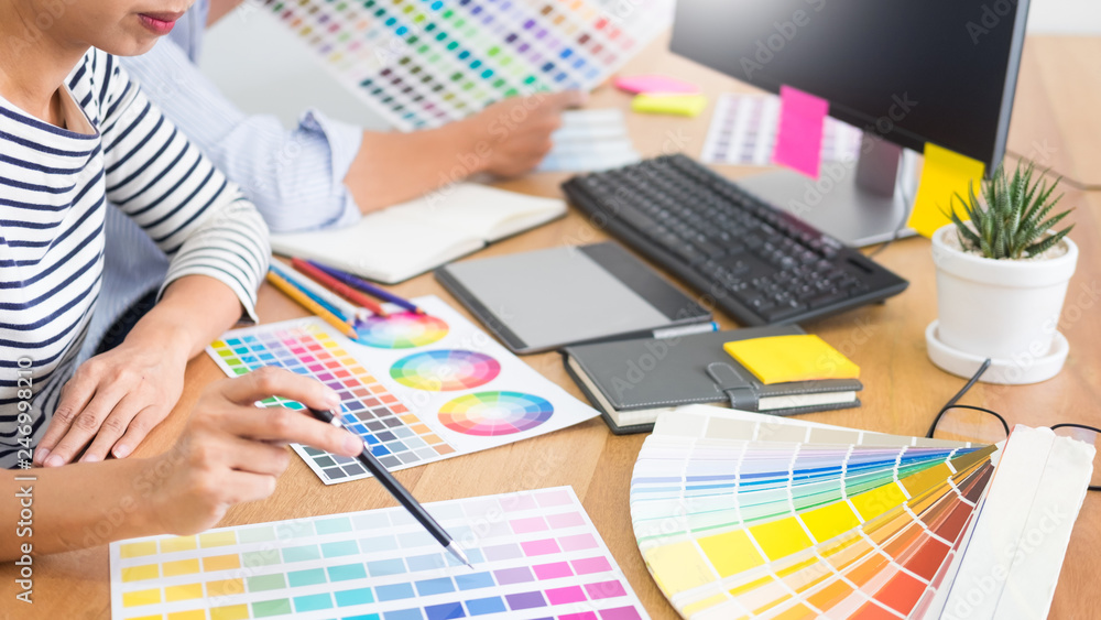 Poster designer graphic creative creativity working together coloring using graphics tablet and a stylus at