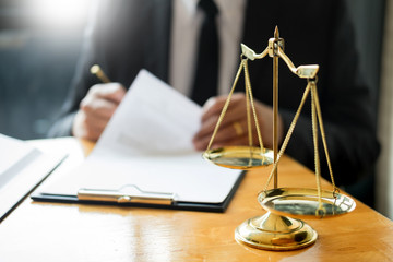 Male lawyer working with contract papers and reading law book in a courtroom, justice and law concept while presiding over trial.