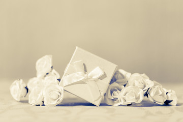 Fototapeta na wymiar Weißes Geschenk zur hochzeit mit Rosen als Deko auf Tisch