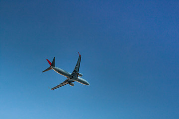 Flying passenger plane on blue sky background