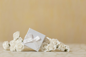 Weißes Geschenk zur hochzeit mit Rosen als Deko auf Tisch