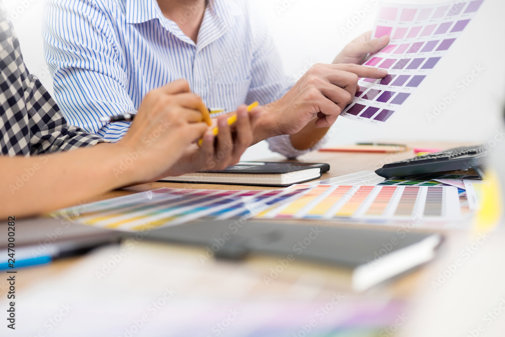 Poster designer graphic creative creativity working together coloring using graphics tablet and a stylus at
