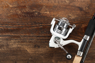 Rubel reel and fishing rod on a wooden background. View from above