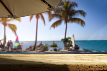 Wooden desk of free space and exotic landscape of sea and palms 