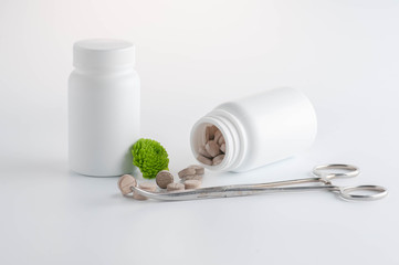 herbal pills with a white box and flowers. white base