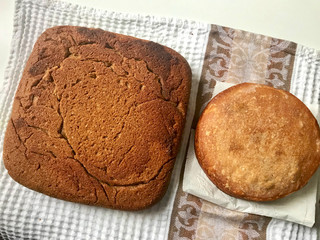 Freshly baked loaves of bread with a ruddy crust cool on a towel.