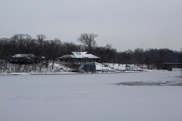 The boathouse and the frozen lake in the park.