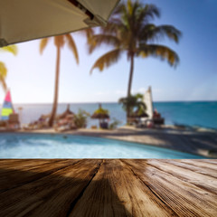 Wooden desk of free space and exotic landscape of sea and palms 