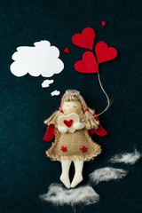 valentine with an angel that goes through the clouds and holds a heart in his hands against a dark background