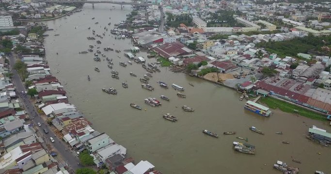 Aerial view, top view of Cai Rang floating market. Tourists and people buy and sell food, vegetable, fruits on boat, ship on river market. Traditional popular method of buying and selling on river
