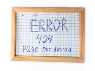 Page not found, server error 404, written on a notebook sheet of paper and inserted in a wooden frame.