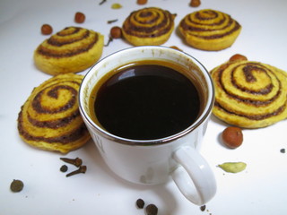 Coffee in a white mug with cookies and nuts