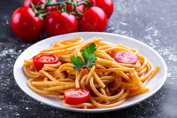 Delicious, homemade pasta with tomato sauce, parsley and fresh vegetables on a plate. Italian food