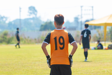 Fototapeta premium Back of young football goalie boy waiting for the ball