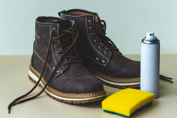 Сleaning men's suede casual boots with sponge and spray. Shoe shine and care. Footwear moisture...