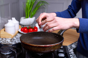Frying fresh, homemade, chicken eggs in the pan at kitchen at home. Cooking a healthy, protein breakfast