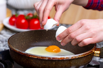 Frying homemade, chicken eggs in the frying pan for a healthy  breakfast. Protein food